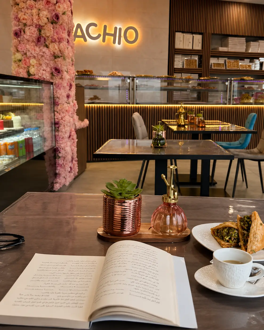 Innenraum des Pistachio Cafés in Saarbrücken mit Blumenwand